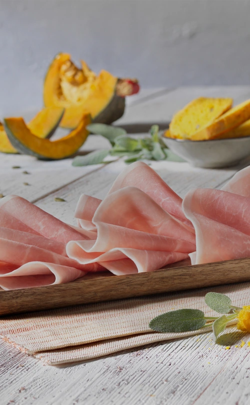 Prosciutto cotto Golfera su tagliere di legno in abbinamento a crostini di zucca